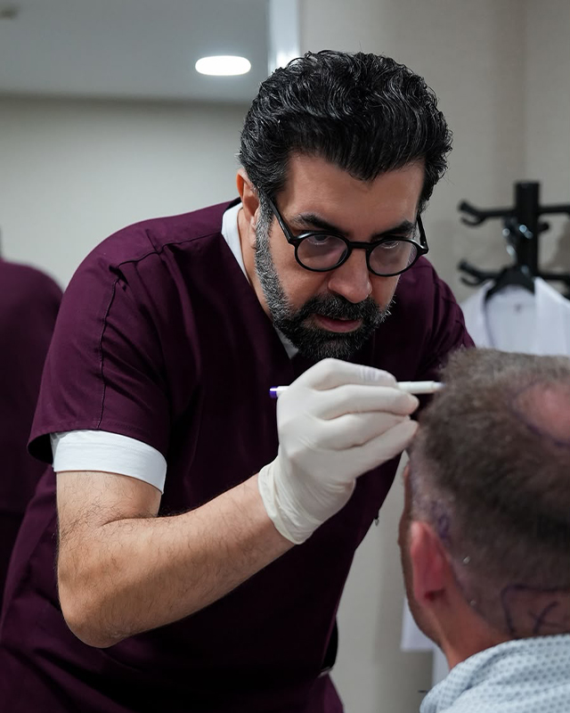 Dr. Emrah Cinik marking a patient's hairline